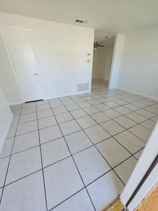 tiled spare room with ceiling fan