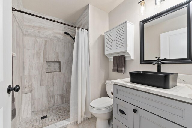 bathroom featuring tile patterned floors, vanity, toilet, and walk in shower