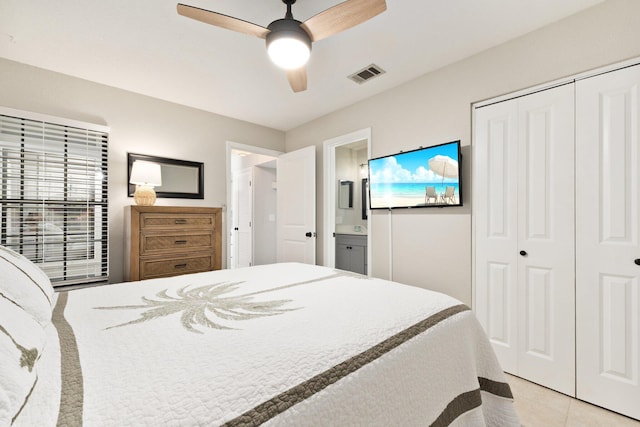 bedroom with ceiling fan, light tile patterned floors, ensuite bathroom, and a closet