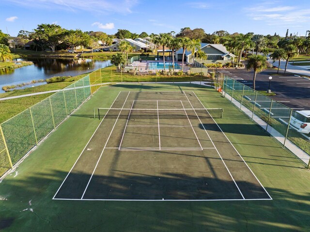 view of tennis court featuring a water view