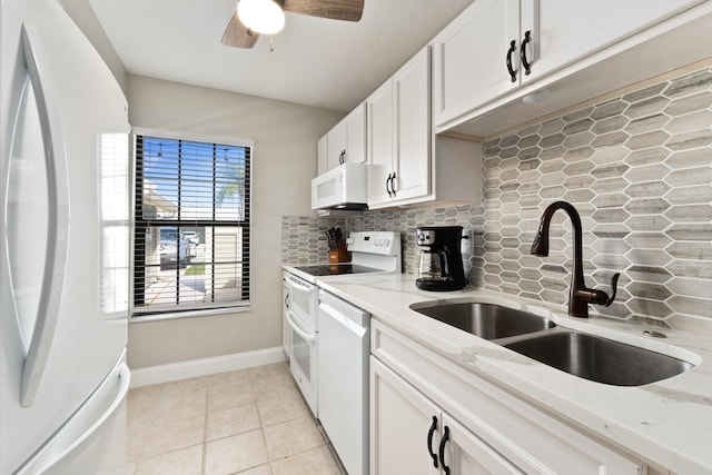 kitchen featuring white cabinetry, sink, backsplash, white appliances, and light stone counters