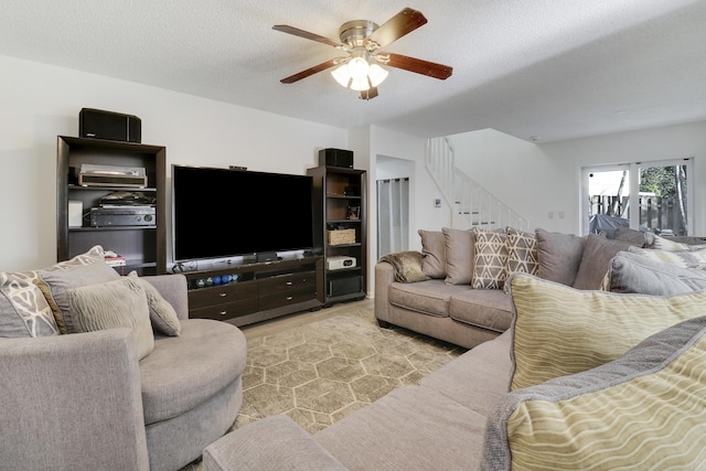 living room with ceiling fan and a textured ceiling