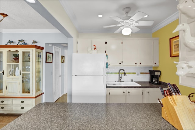 kitchen with white cabinets, white refrigerator, and sink