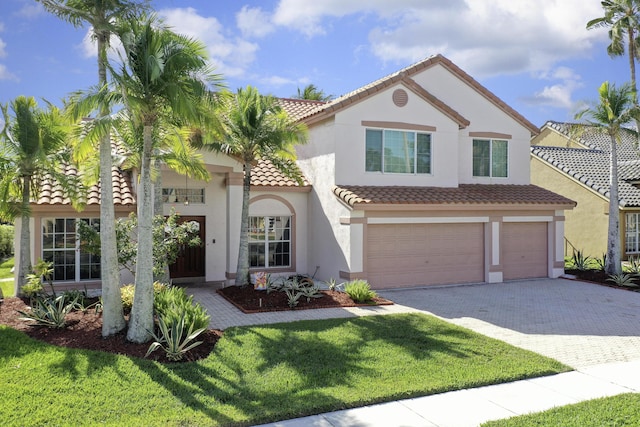 mediterranean / spanish-style house featuring a garage and a front lawn