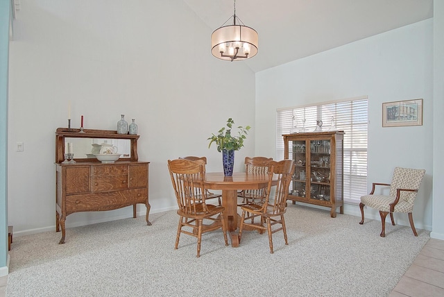 dining area with light carpet, an inviting chandelier, and lofted ceiling