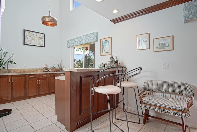 bar featuring pendant lighting, ornamental molding, and light tile patterned floors