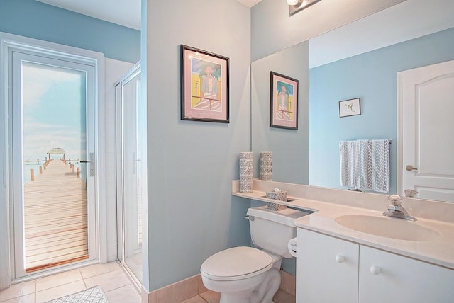 bathroom featuring tile patterned flooring, vanity, a shower with door, and toilet