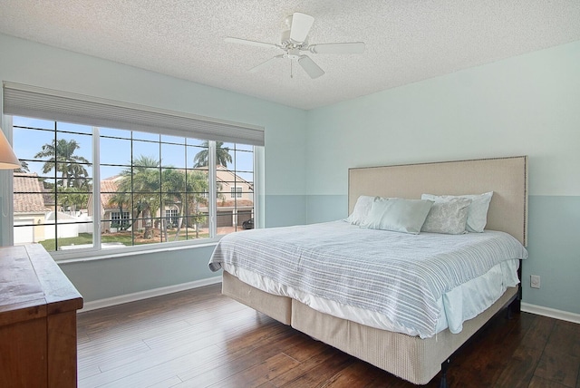 bedroom featuring a textured ceiling, dark hardwood / wood-style floors, and ceiling fan