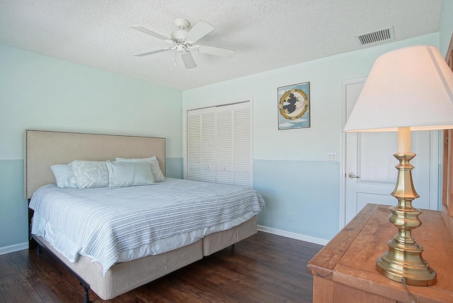 bedroom with a textured ceiling, dark hardwood / wood-style floors, a closet, and ceiling fan