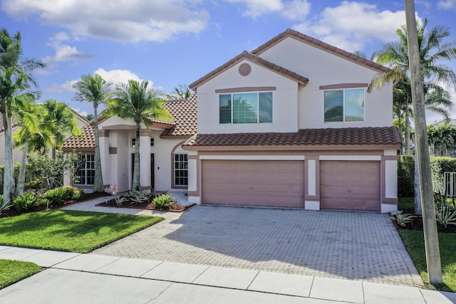 mediterranean / spanish-style house with a garage and a front lawn