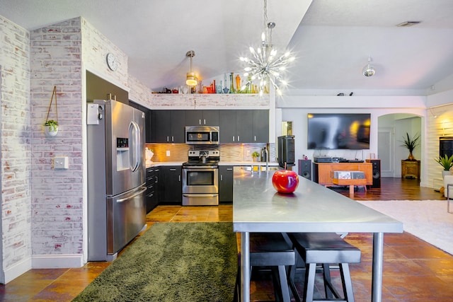 kitchen featuring appliances with stainless steel finishes, light countertops, vaulted ceiling, and dark cabinets