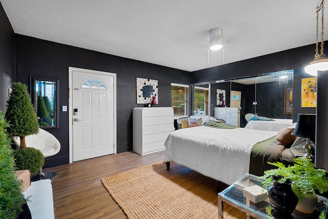 bedroom featuring ceiling fan, a textured ceiling, and wood finished floors