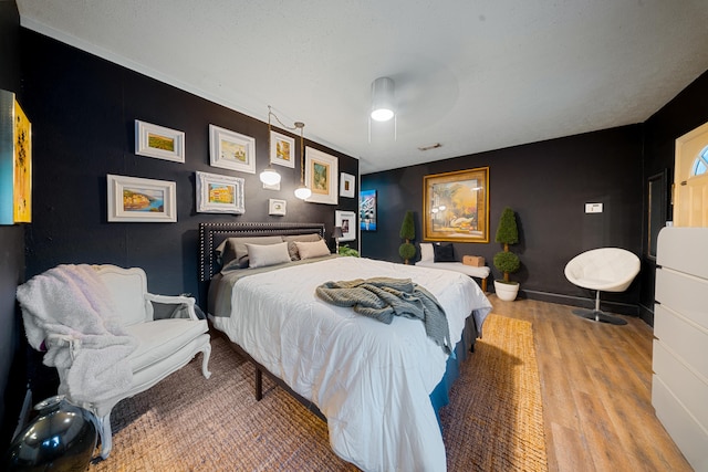 bedroom with baseboards, a ceiling fan, and wood finished floors