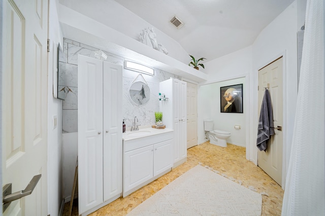 bathroom with vaulted ceiling, visible vents, vanity, and toilet