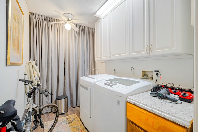 laundry area featuring cabinet space, ceiling fan, light wood-style flooring, and washing machine and clothes dryer