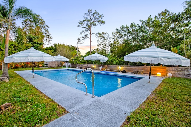 view of swimming pool featuring a fenced in pool, a fenced backyard, and a yard