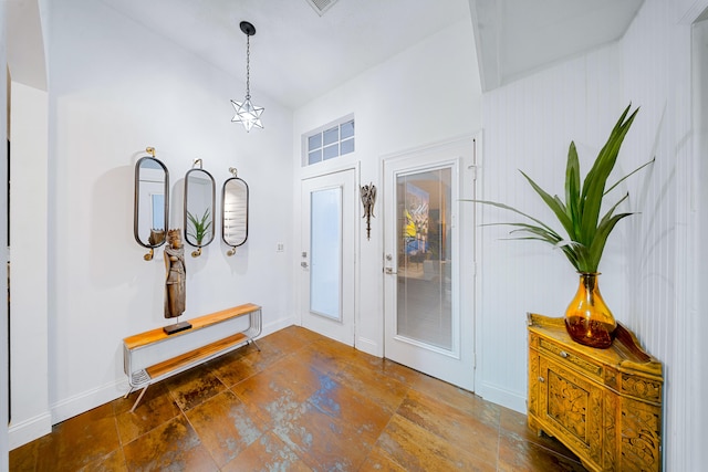 entrance foyer featuring lofted ceiling and baseboards