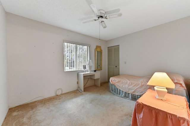 carpeted bedroom featuring ceiling fan and a closet