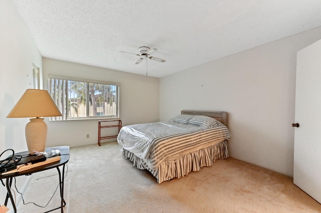 carpeted bedroom featuring a textured ceiling and ceiling fan