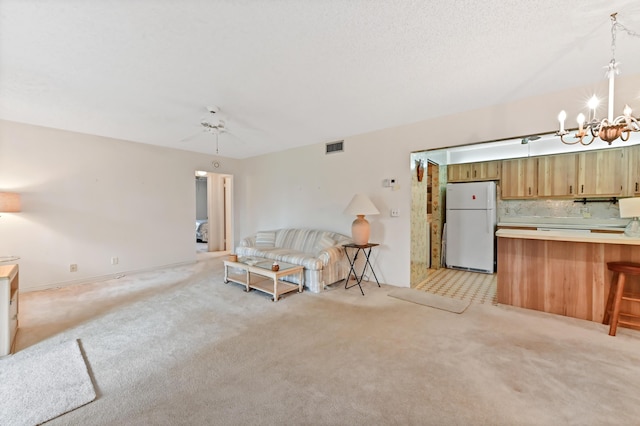 unfurnished living room featuring light carpet and ceiling fan with notable chandelier