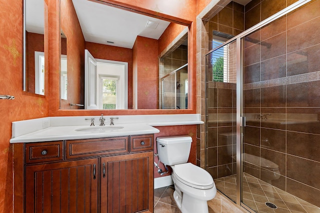 bathroom with tile patterned flooring, vanity, an enclosed shower, and toilet