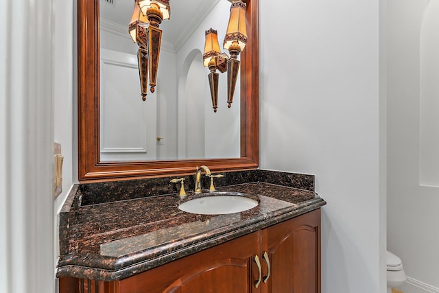 bathroom featuring crown molding, vanity, and toilet