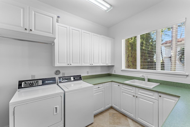 clothes washing area with washer and dryer, cabinets, light tile patterned floors, and sink