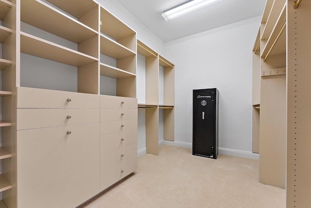 walk in closet featuring light colored carpet