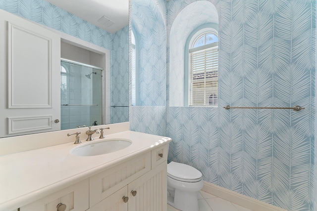 bathroom with tile patterned floors, vanity, toilet, and a shower with door