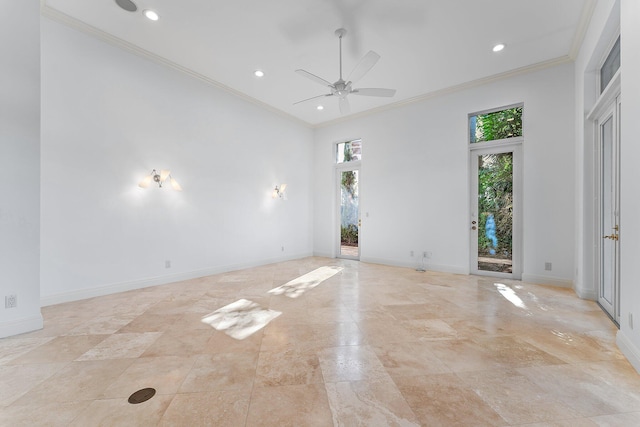 empty room with ceiling fan, crown molding, and a high ceiling