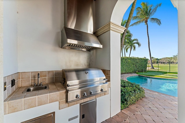 view of patio featuring a fenced in pool, area for grilling, and sink