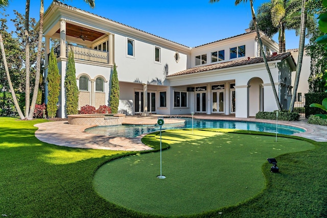 back of property featuring ceiling fan and a balcony