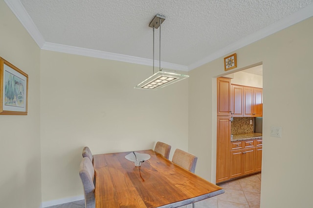 dining area with a textured ceiling, ornamental molding, and light tile patterned flooring