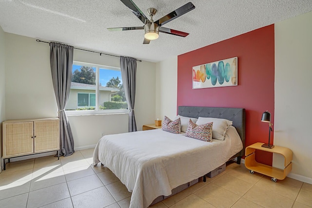 bedroom with a ceiling fan, tile patterned flooring, a textured ceiling, and baseboards