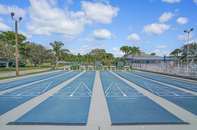 view of property's community featuring fence and shuffleboard