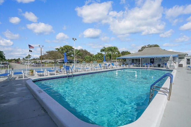 pool with a patio area and fence