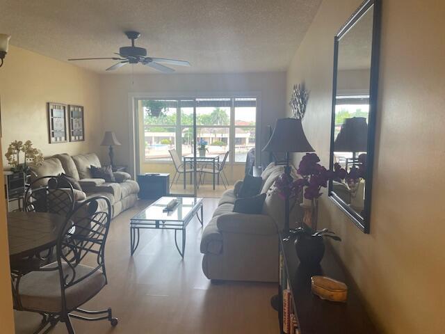 living room with a textured ceiling and ceiling fan