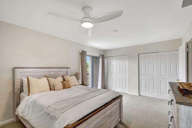 bedroom featuring carpet flooring, ceiling fan, and multiple closets