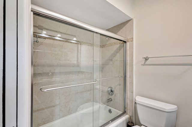 bathroom with shower / bath combination with glass door and toilet