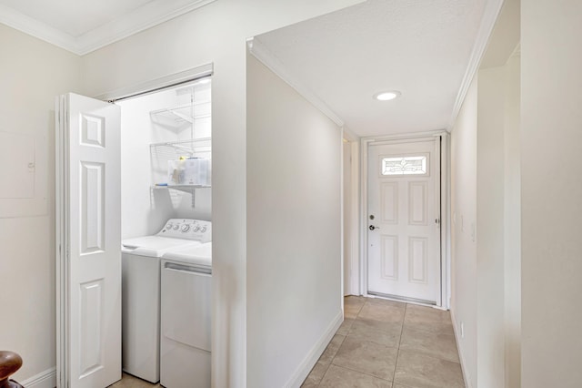 laundry area featuring washing machine and dryer, crown molding, and light tile patterned floors