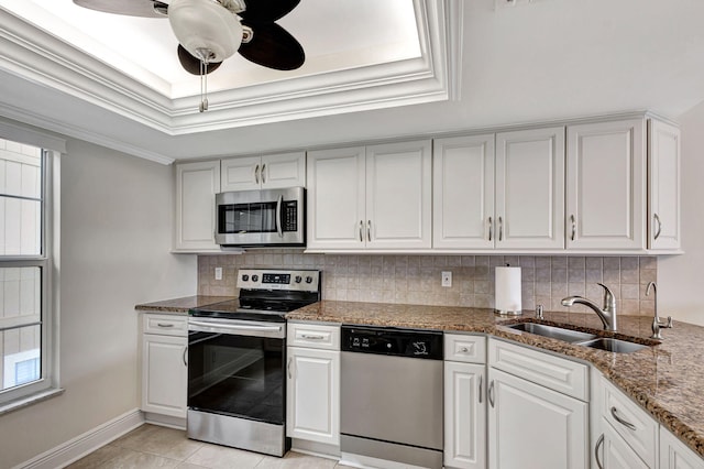 kitchen featuring sink, a raised ceiling, light tile patterned flooring, white cabinets, and appliances with stainless steel finishes