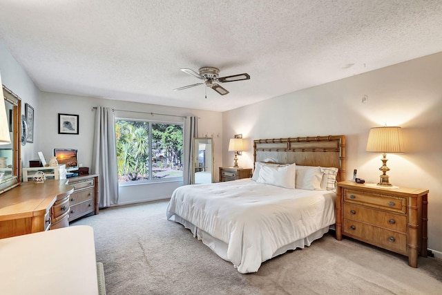 bedroom featuring a textured ceiling, ceiling fan, and light carpet