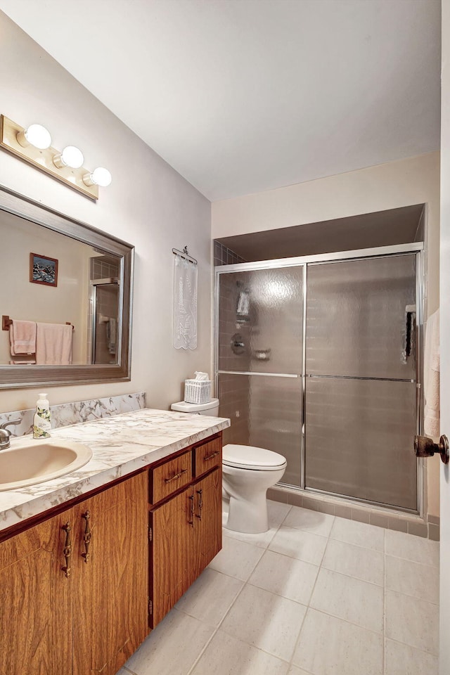 bathroom with tile patterned flooring, vanity, and a shower with door