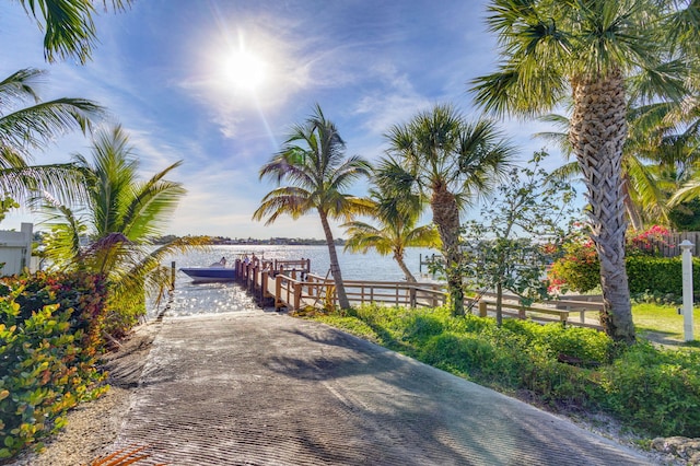 view of home's community with a water view and a dock