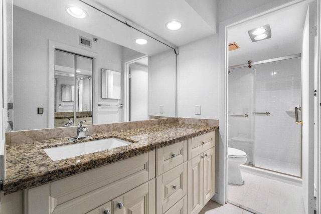 bathroom featuring tile patterned floors, vanity, toilet, and walk in shower