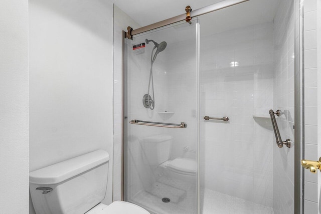 bathroom featuring toilet and an enclosed shower