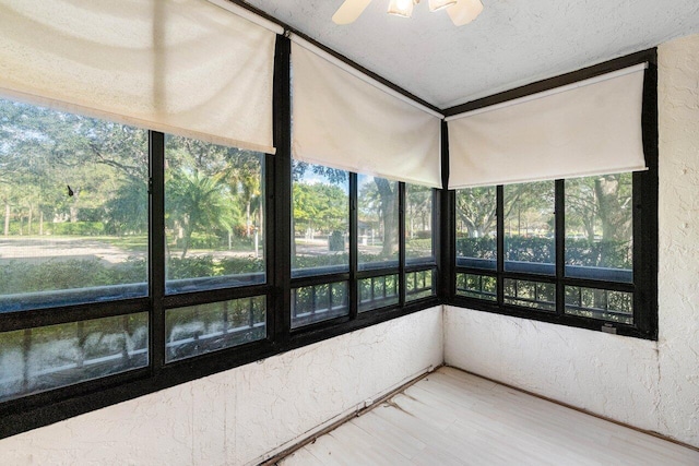 unfurnished sunroom with ceiling fan