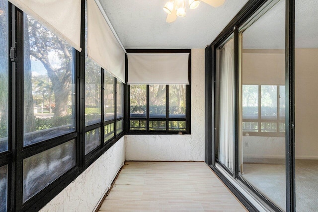 unfurnished sunroom with ceiling fan