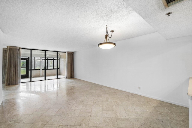 spare room featuring a textured ceiling and floor to ceiling windows