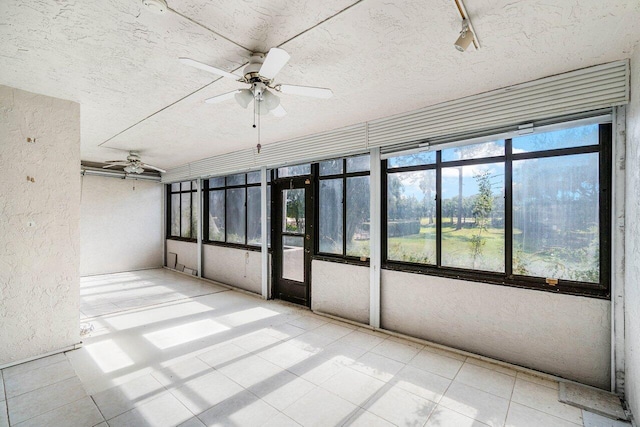 unfurnished sunroom with ceiling fan